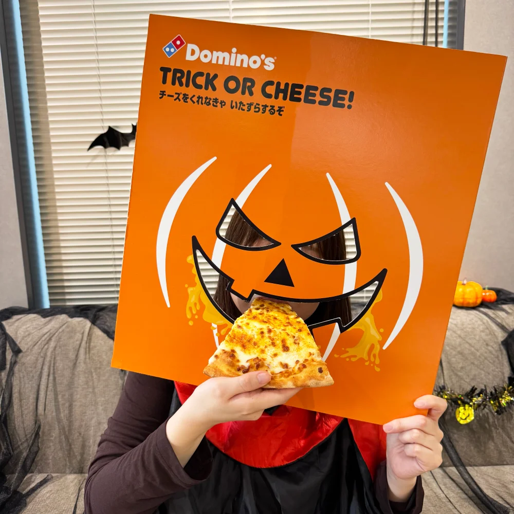 ハロウィンボックスの顔はめお面でピザを食べる人