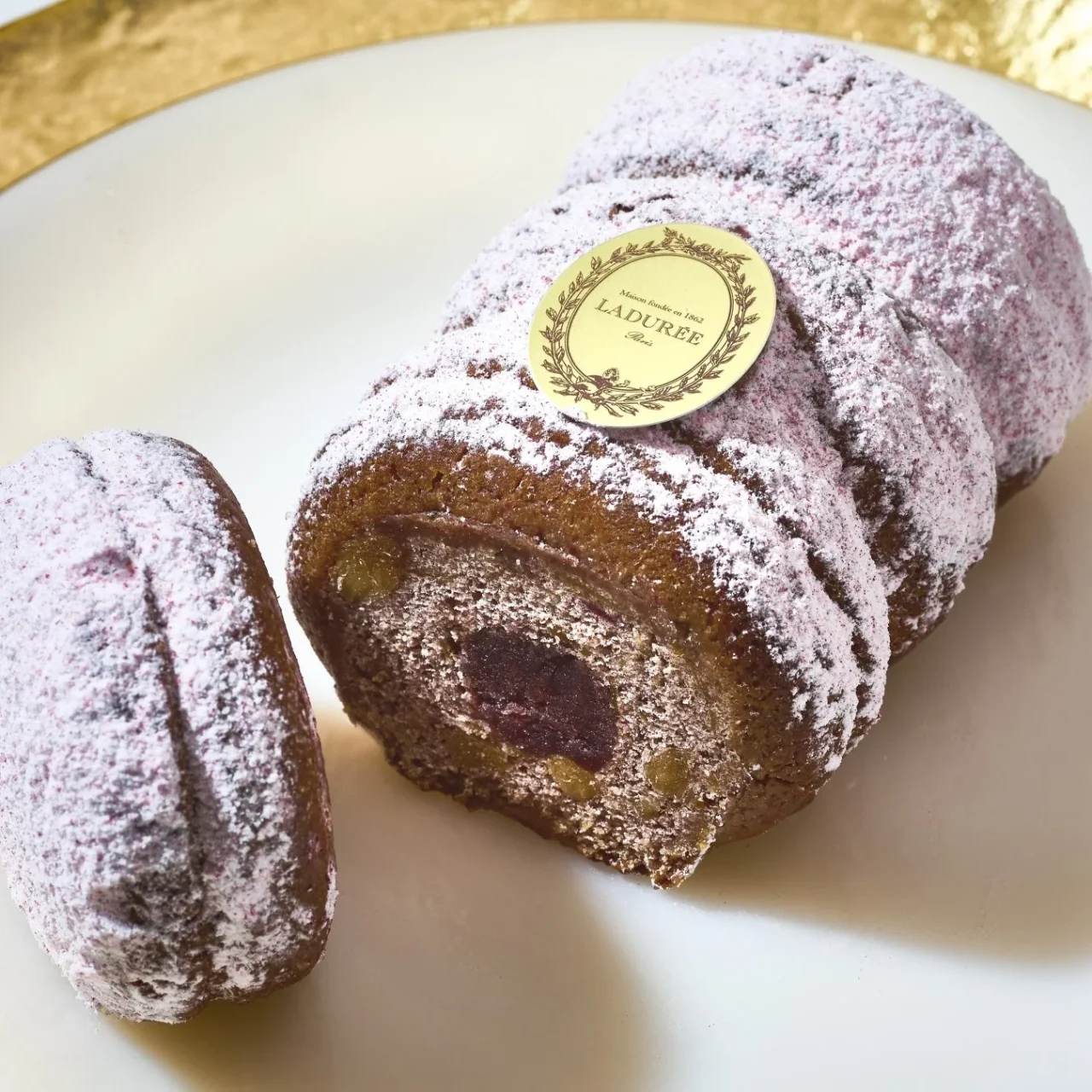 ピンクの粉糖をまとったシュトーレン・イスパハンの断面とラデュレのロゴ入りメダイヨン