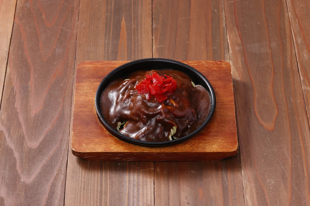 アパ社長カレー焼ラーメン。鉄板皿にカレーがかかり紅しょうがが載る