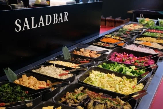 黒い容器に多種類の料理が並ぶ「SALAD BAR」のビュッフェ台