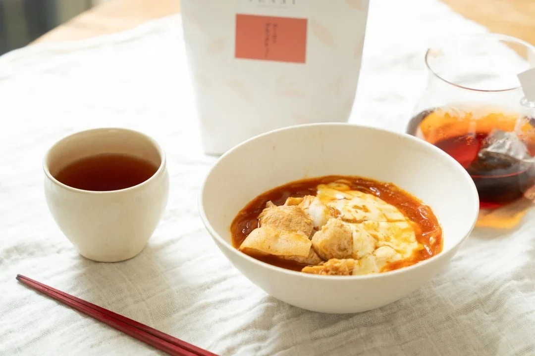 麻辣湯にスライスチーズを加えた器と、TEAET ウーロンブラックティーの湯のみ