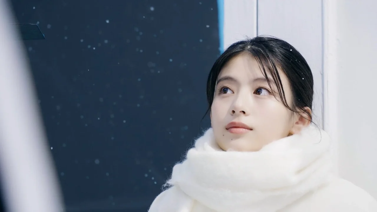 メルティーキッスCM撮影で白いマフラー姿で雪空を見上げる出口夏希さん