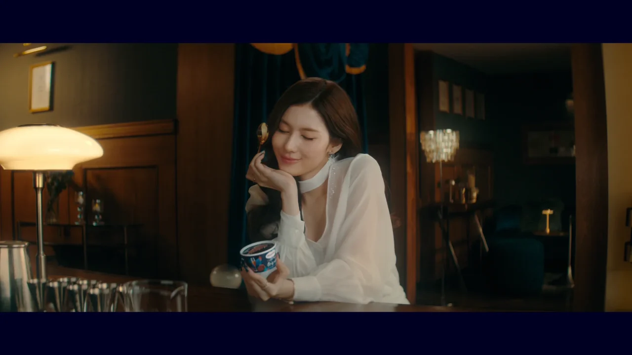 WEB CM「しあわせな余韻」篇の場面。白いブラウスの女性がカップを手に微笑む