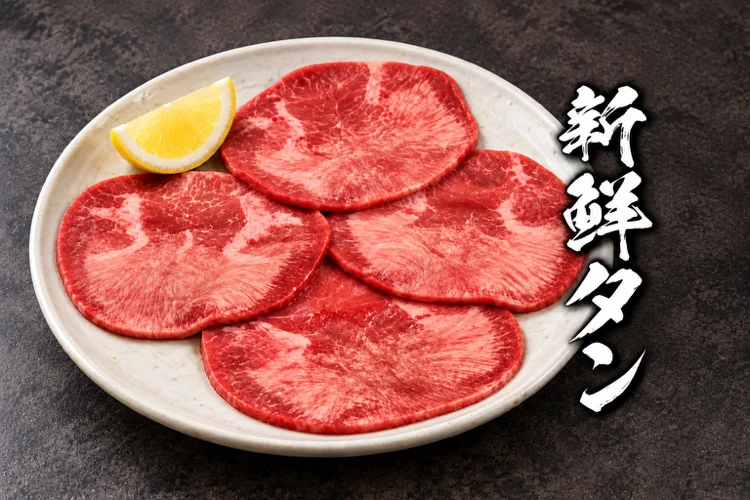 白い皿にレモンを添えた牛上塩タンの薄切り4枚