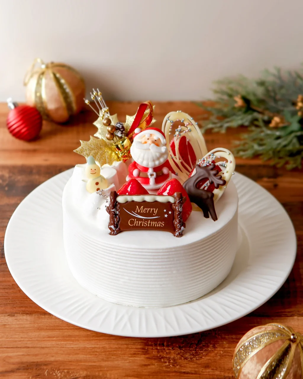 五感のクリスマスデコレーション。サンタやMerry Christmasのプレートをのせた白い生クリームのケーキ