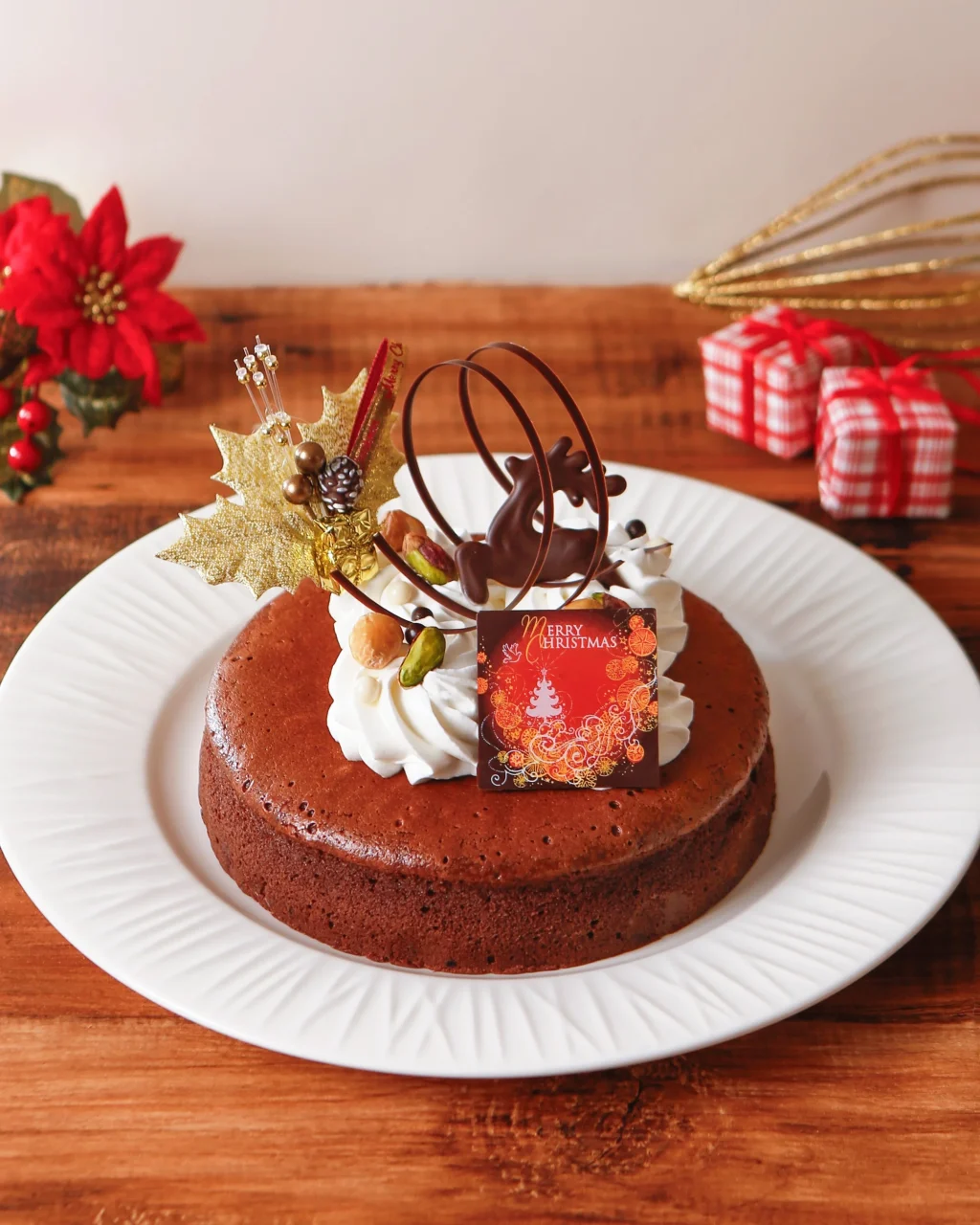 ガトーショコラ・ノエル。生クリームとチョコ飾りのトナカイをのせた丸いチョコケーキ