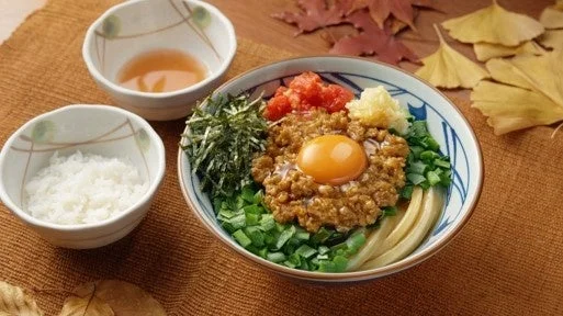 肉辛まぜうどん。卵黄、ニラ、刻み海苔をのせた器と白ご飯