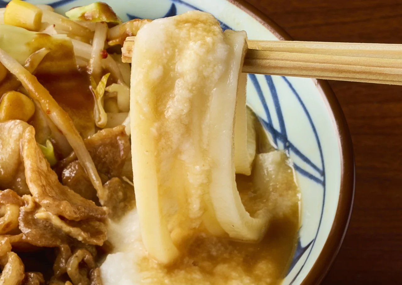 濃厚味噌だしうどんにとろろをのせ、箸で持ち上げた麺