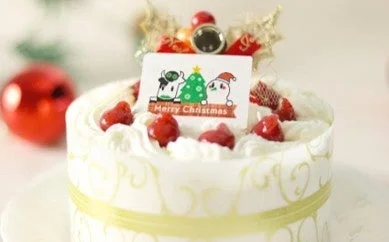 いちごと生クリームで飾られたMerry Christmasプレート付きの白いホールケーキ