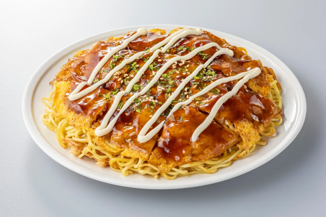 白い皿に盛られたソースとマヨネーズのかかったお好み焼き