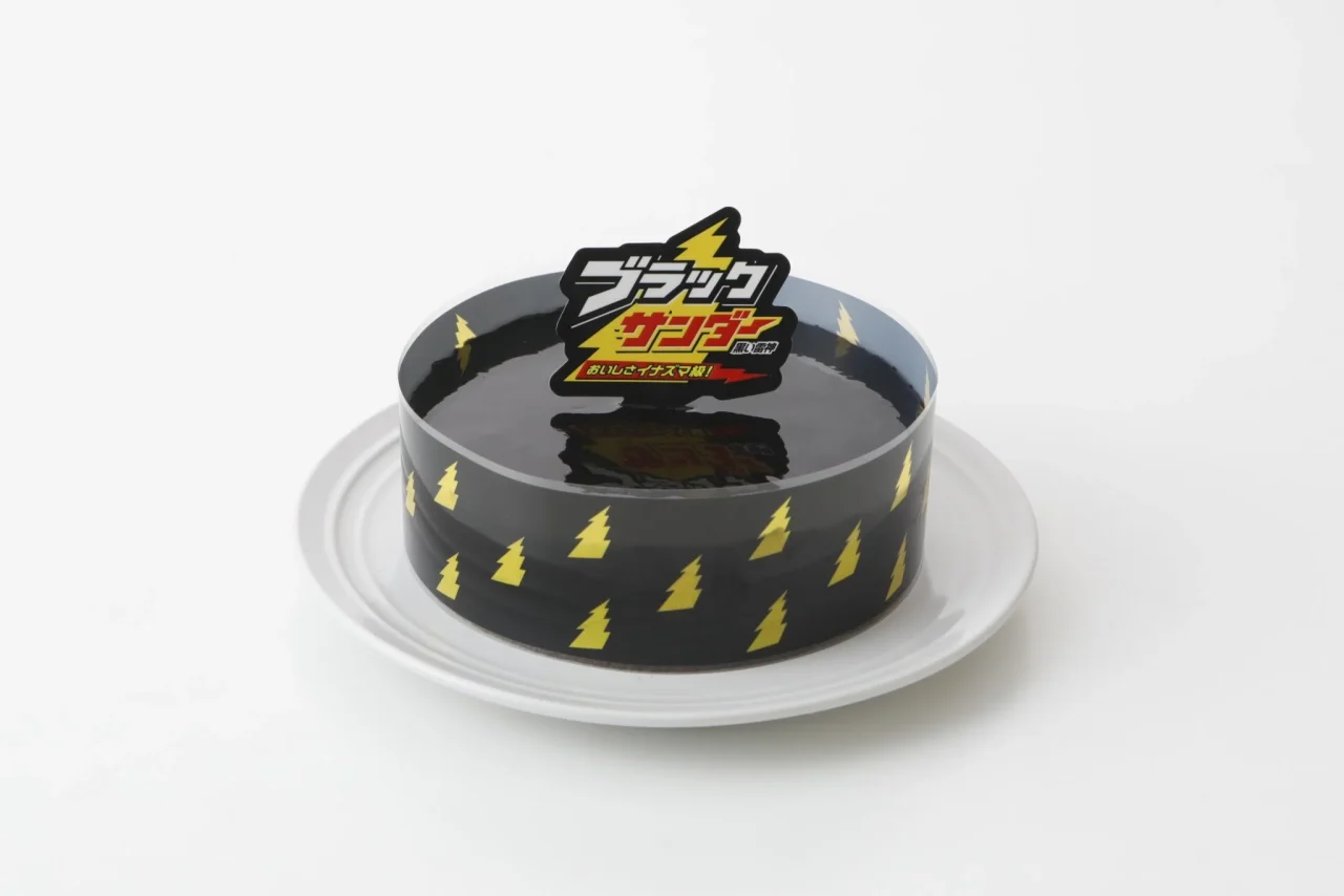ブラックサンダーケーキ。黒い稲妻柄のスリーブとロゴプレートを付けた丸いケーキ