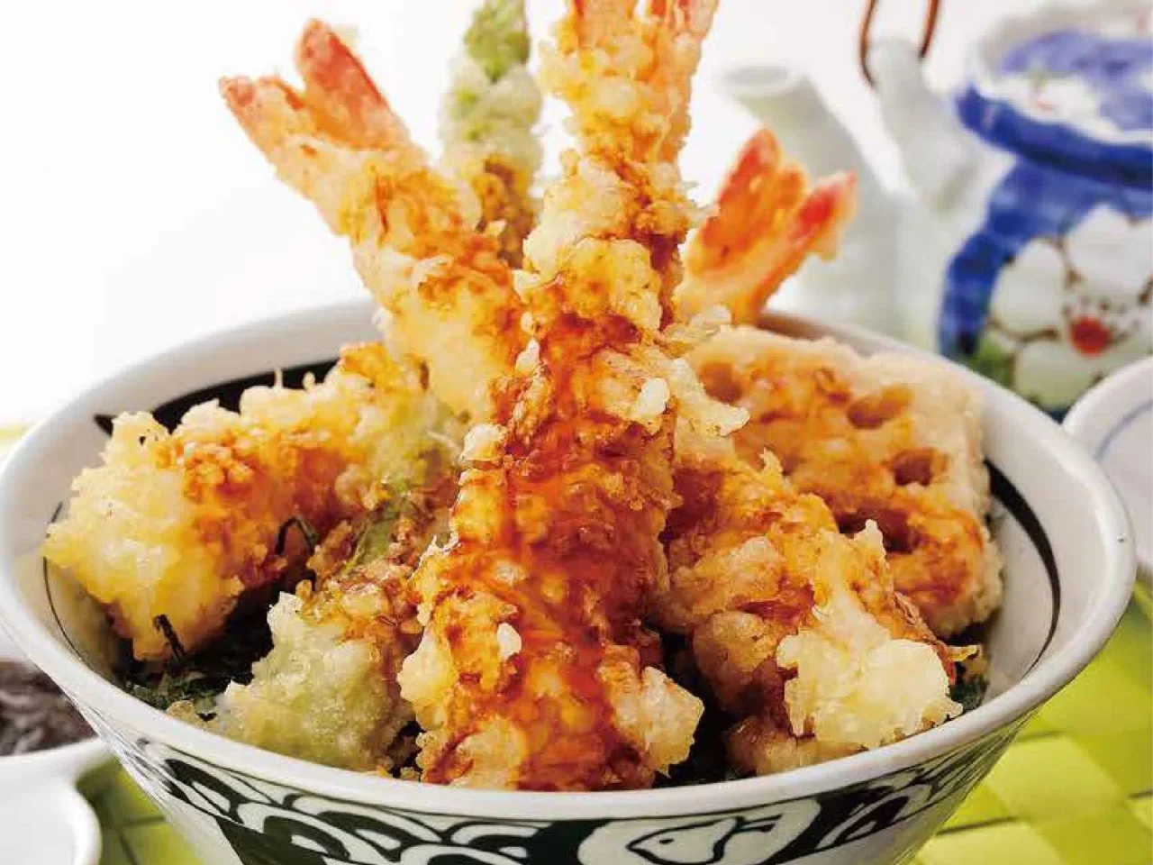 海老天丼（イメージ）。器に海老天などの天ぷらがたれ付きで盛られている