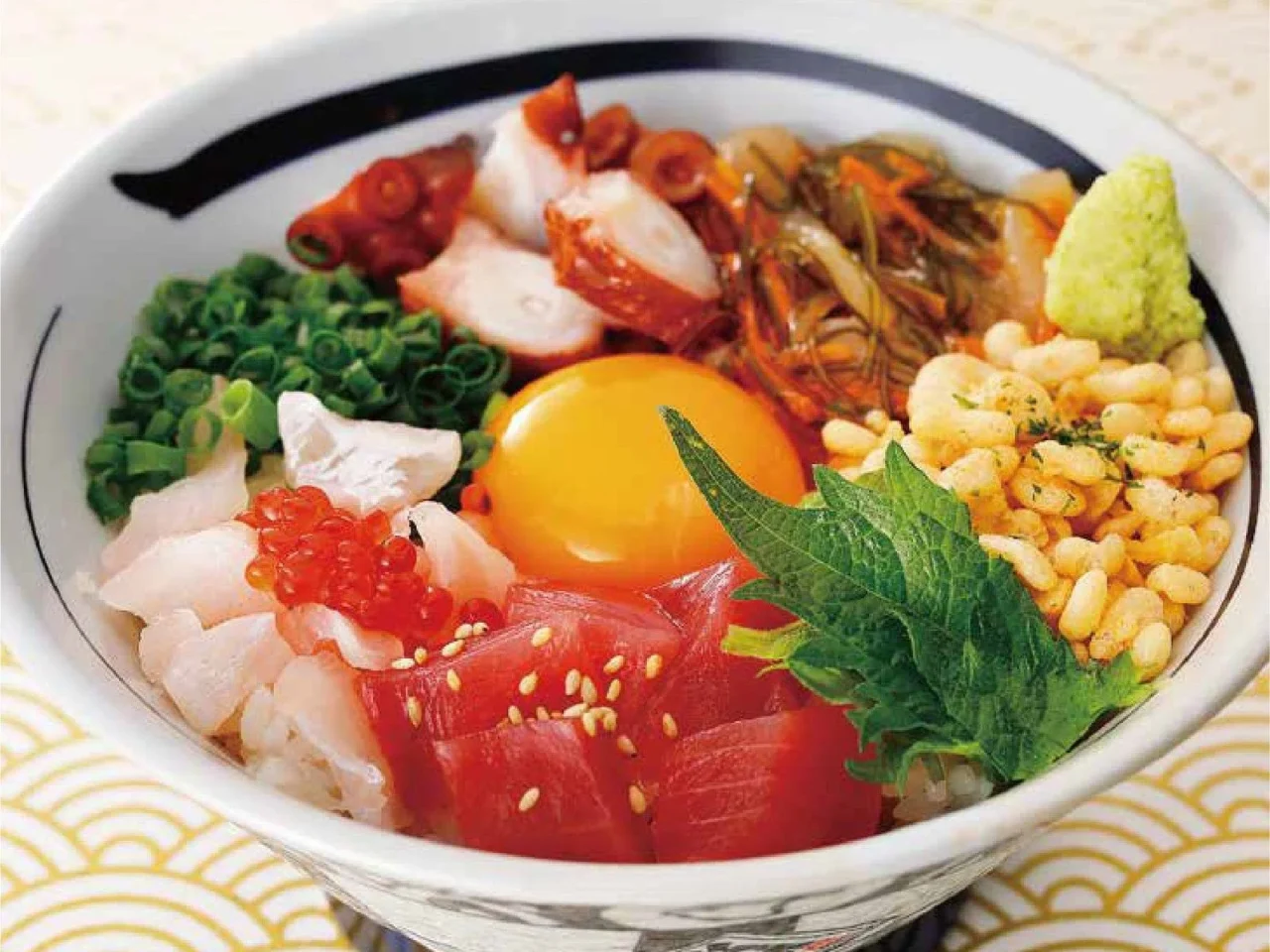 旨味源ちゃん丼のイメージ。刺身や卵黄、いくら、天かすをのせた丼