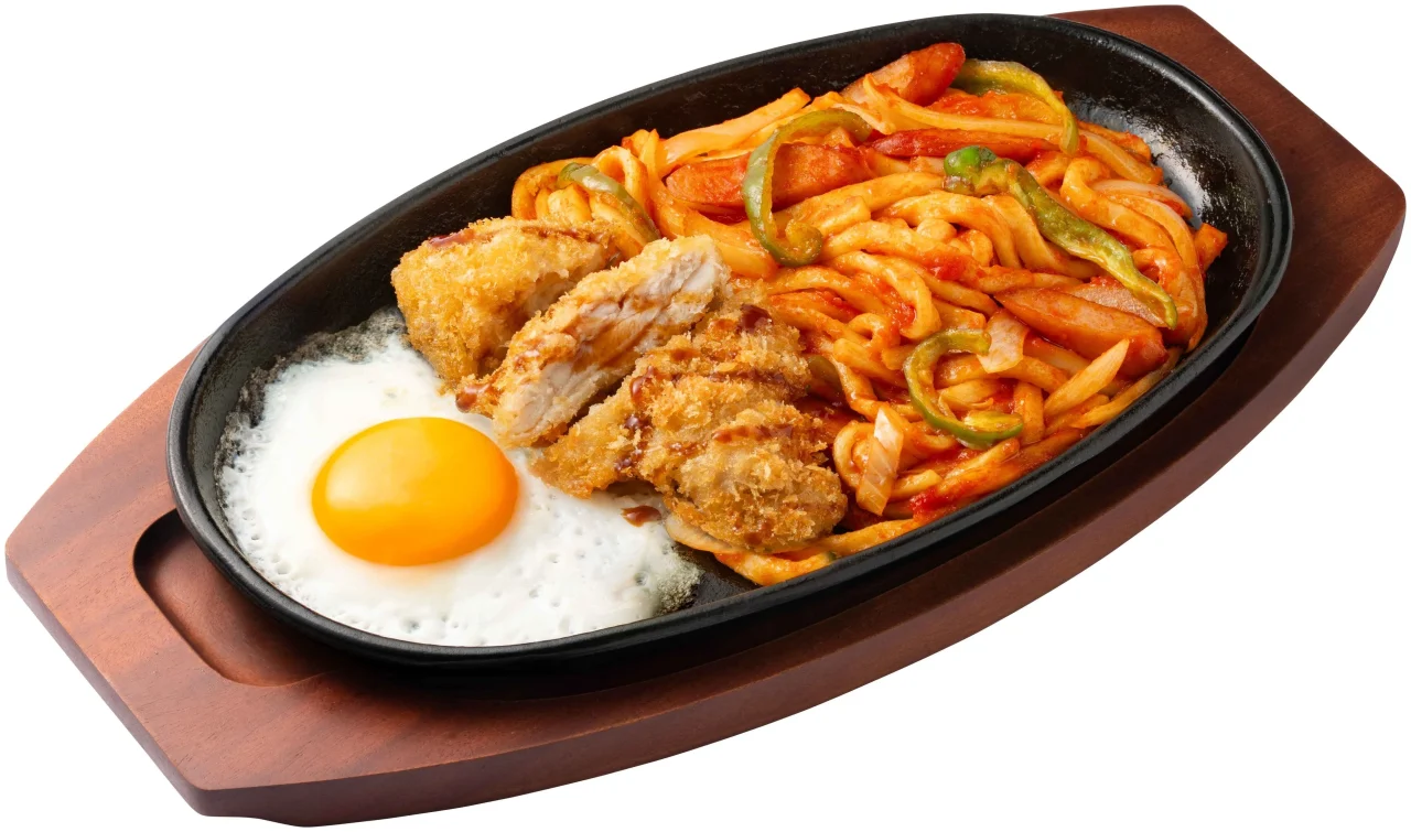 鉄板に盛られたチキンカツのせナポリタンうどんと目玉焼き