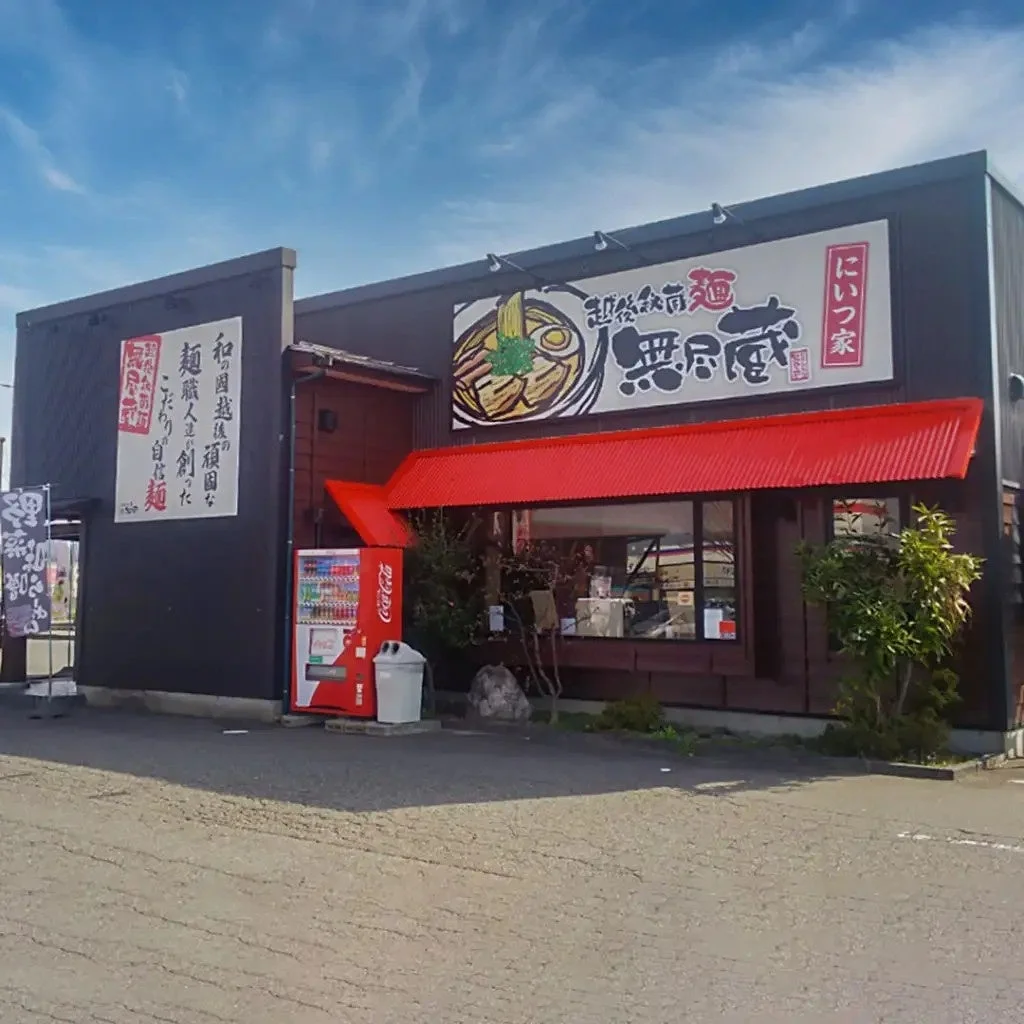 新潟らーめん 無尽蔵 にいつ家の店舗外観。赤い庇と看板