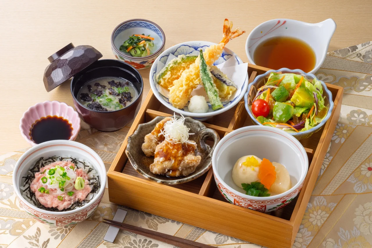 お楽しみ御膳『小町』。小丼、天ぷら、唐揚げ、サラダ、小鉢が木の枠に並ぶ