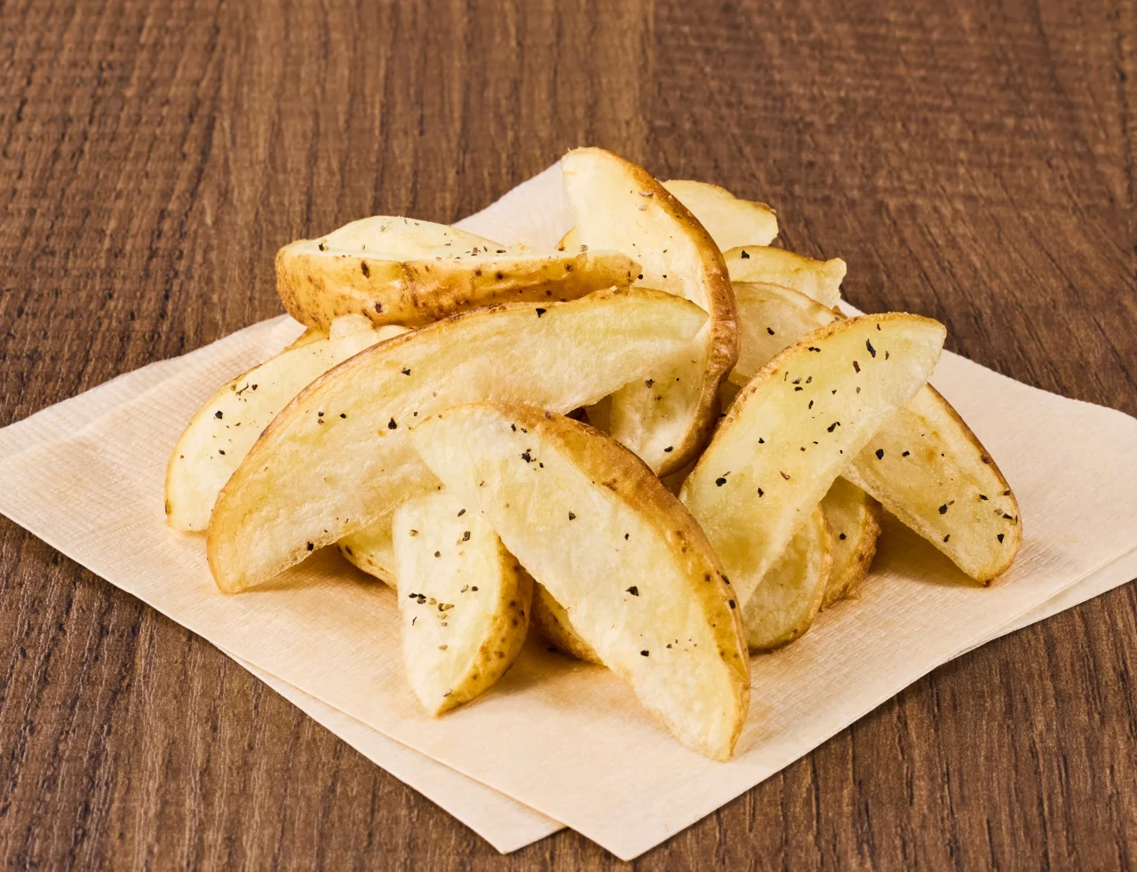 北海道産フライドポテト（トヨシロ）。皮付きのくし形ポテトが紙の上に盛られている
