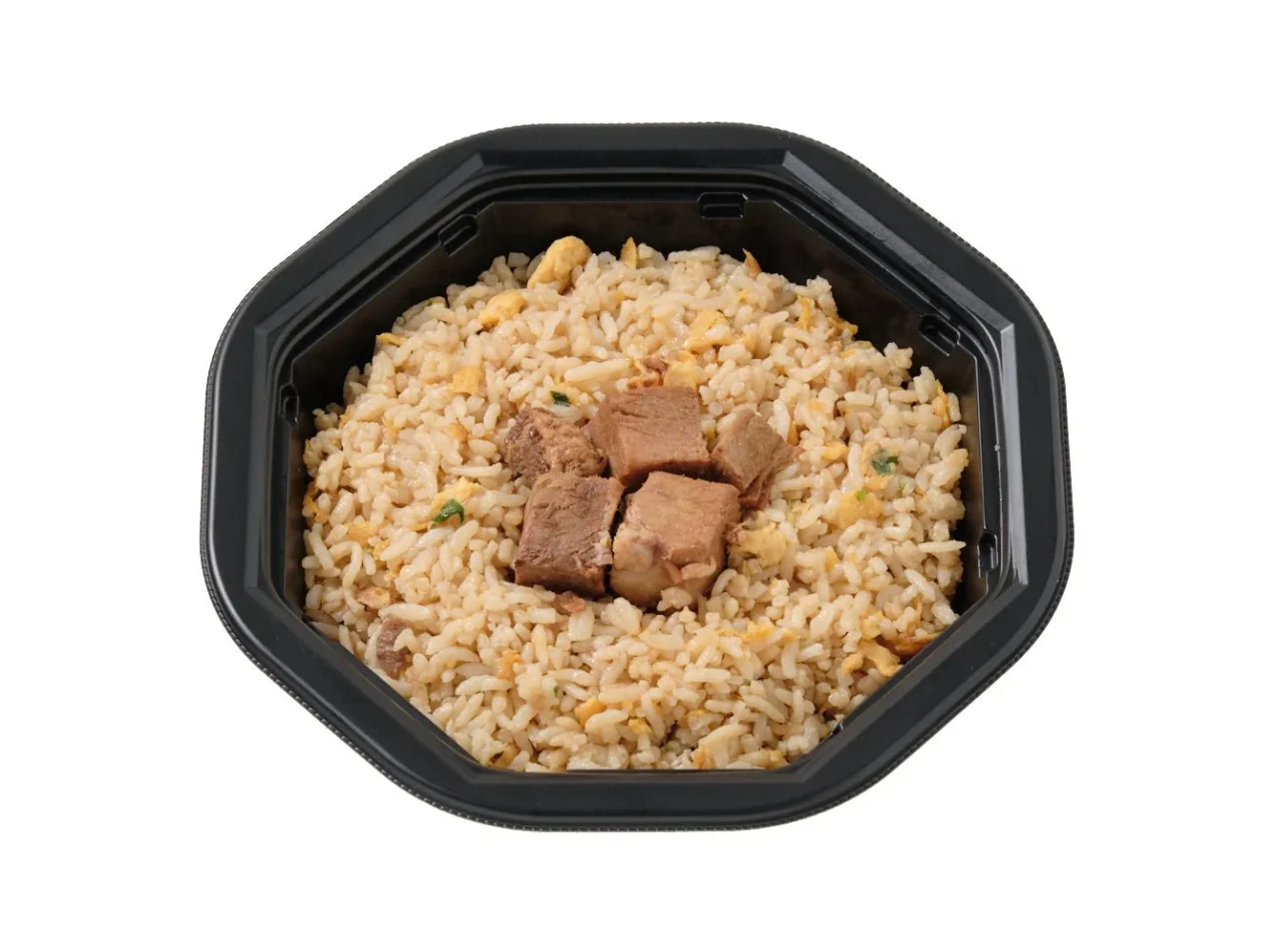 黒い八角形の容器に入った、肉のかたまりをのせたチャーハン