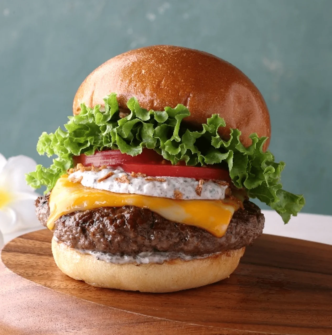 トリュフ コルビージャック チーズバーガー。パティとチーズ、レタス、トマトを挟んだ外観