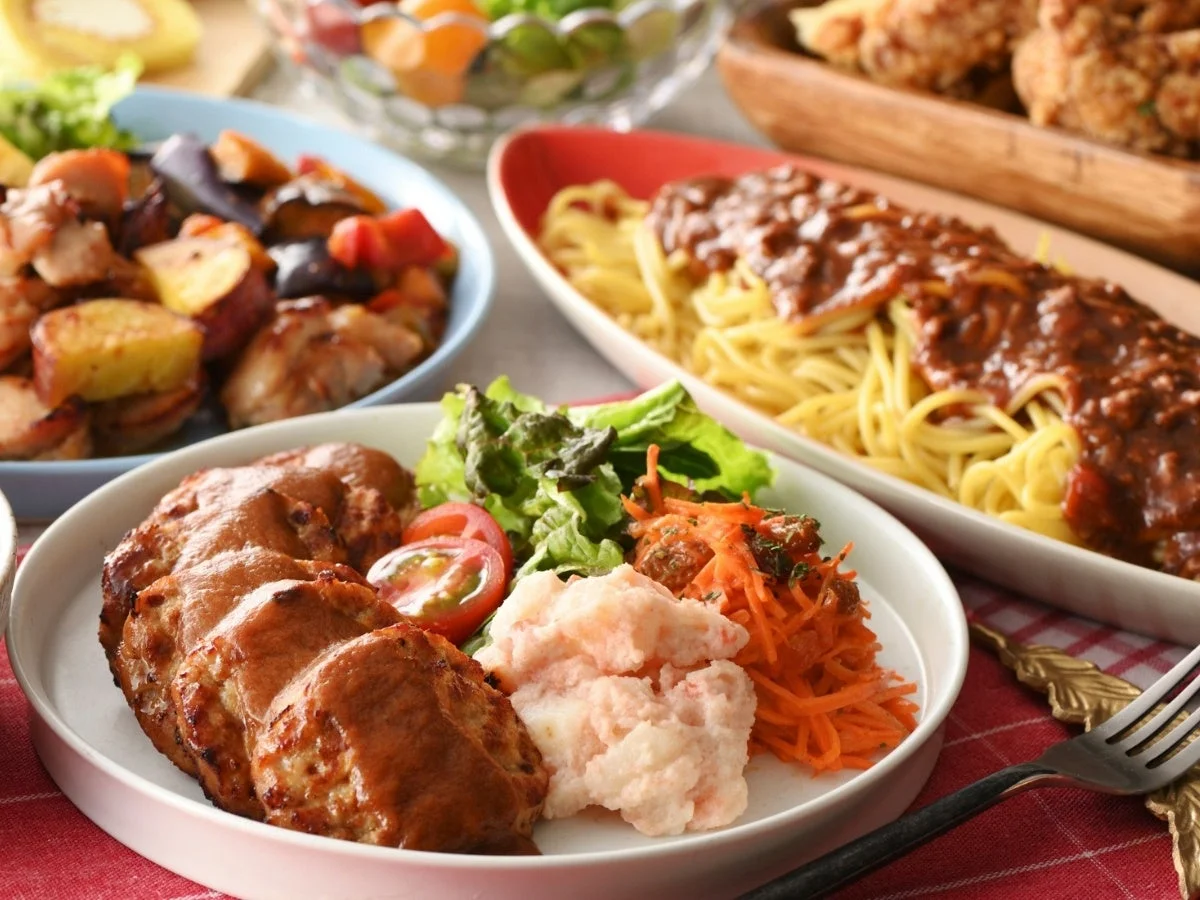 ニラックスブッフェの料理。ハンバーグ、サラダ、スパゲッティ、野菜のグリル