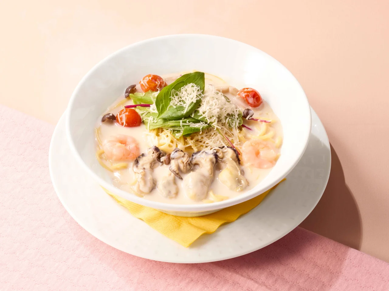 たっぷり牡蠣のクリームスープパスタ。海老やトマト、ベビーリーフが載る