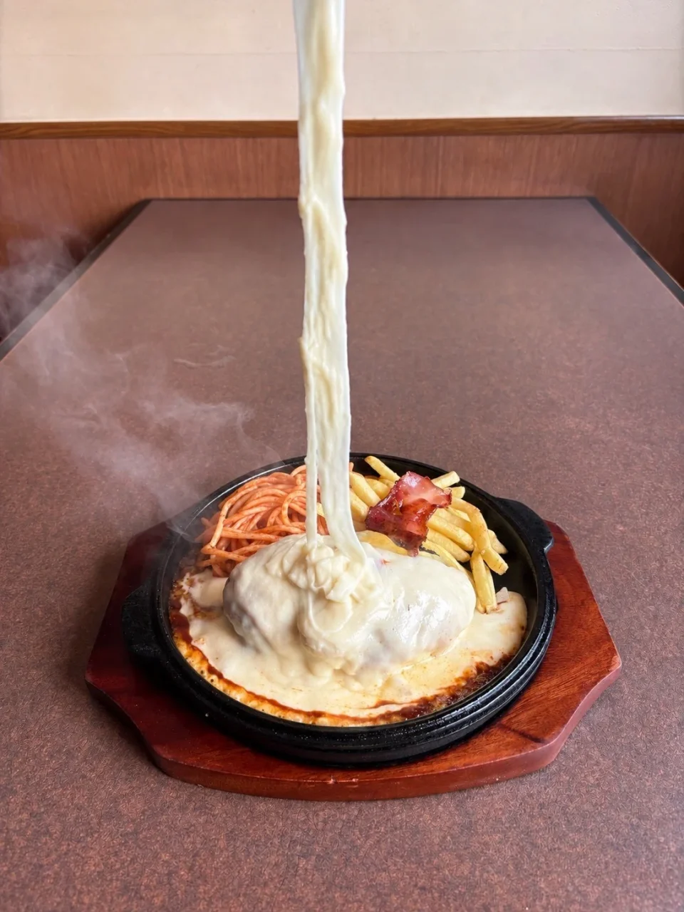 背徳のやりすぎチーズハンバーグ。鉄板に大量のチーズが伸びる