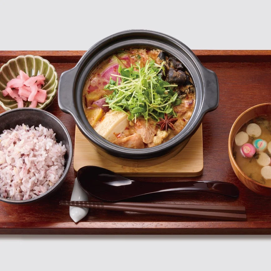 鶏白湯土鍋膳～麻辣豆乳～。土鍋にご飯、漬物、汁物を添えた膳