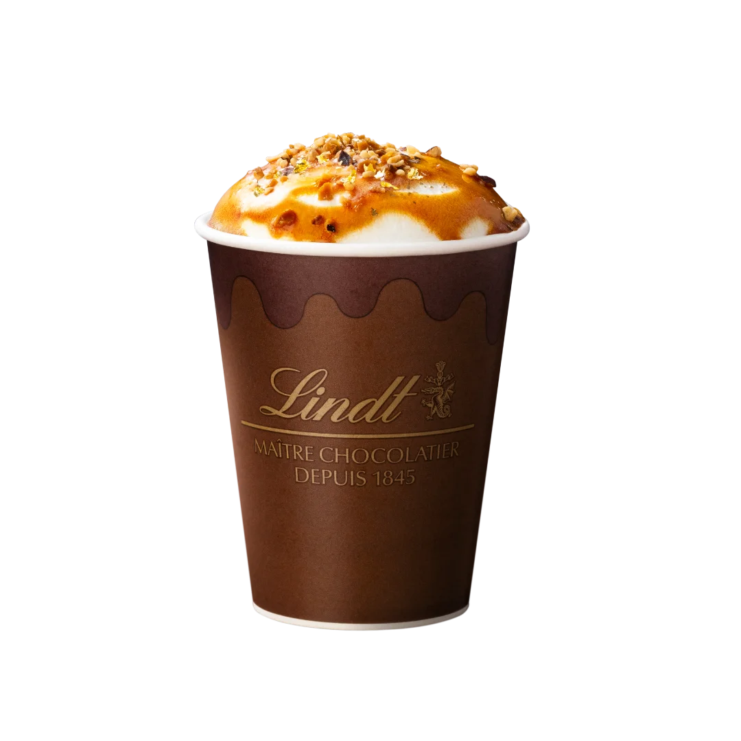 ゴールデンキャラメル ショコラドリンク ホット。Lindtロゴ入り茶色いカップにキャラメルとナッツ