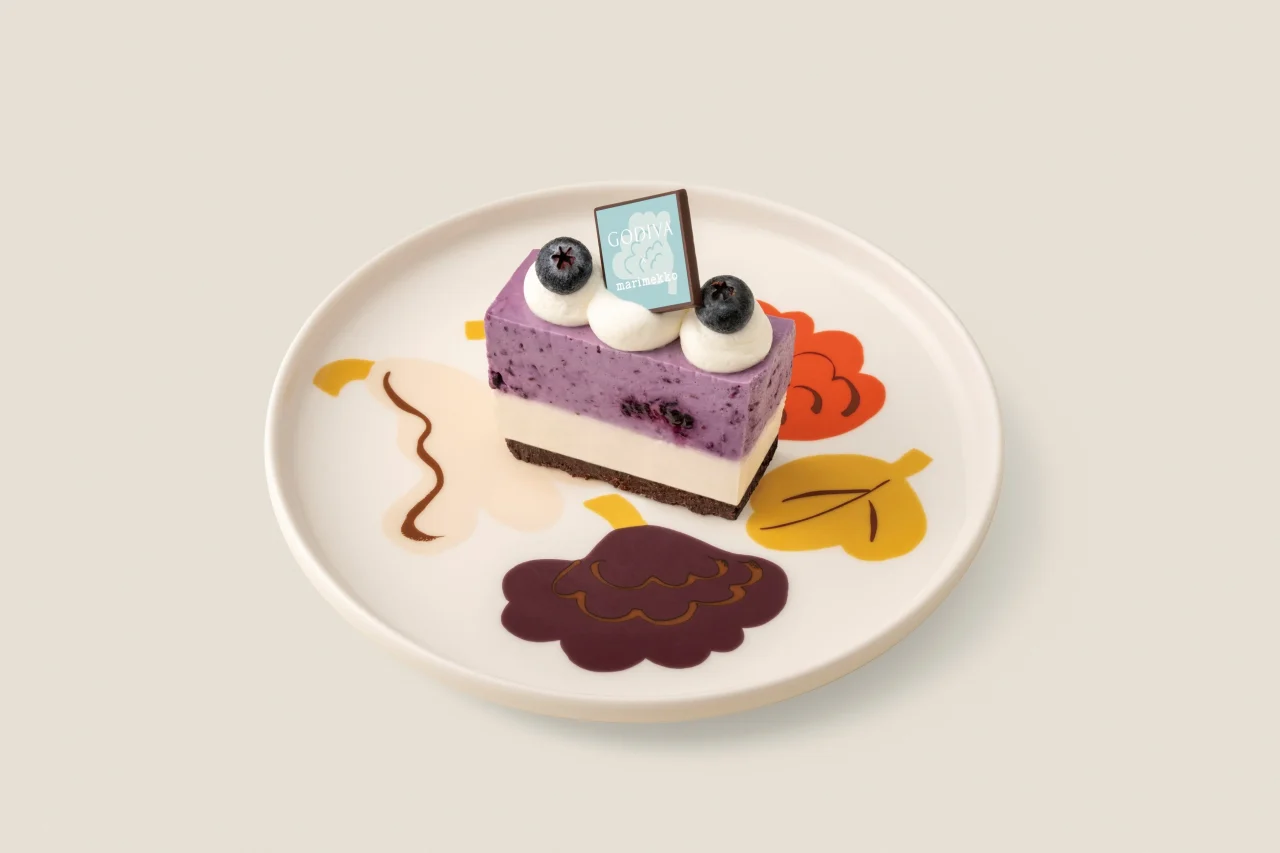 レアチーズケーキ(ブルーベリー+カカオフルーツ)のロゴチョコプレート付き一切れ