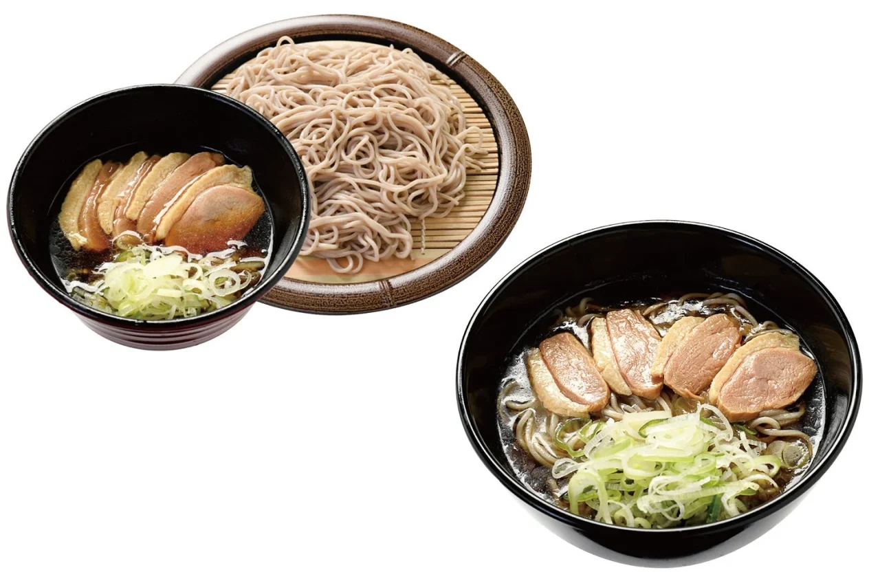 鴨そば。鴨肉とネギをのせた黒い丼と、ざるに盛ったそば